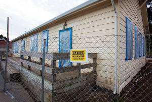 house with fence and lead warning sign