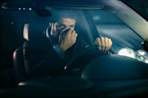 tired driver with fingers on nose