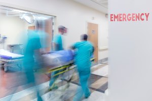 doctors rushing hospital bed through hallway