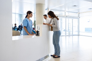 A woman at a nursing station in a hosptal.