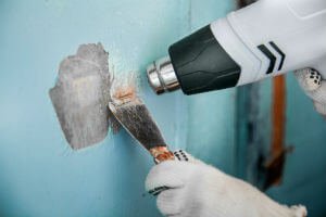 using a heat gun to remove lead paint from a wall