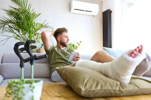 man on couch with leg in cast
